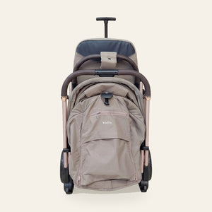 La poussette Kidilo 6530 MINI pliée en trolley, poignée télescopique relevée